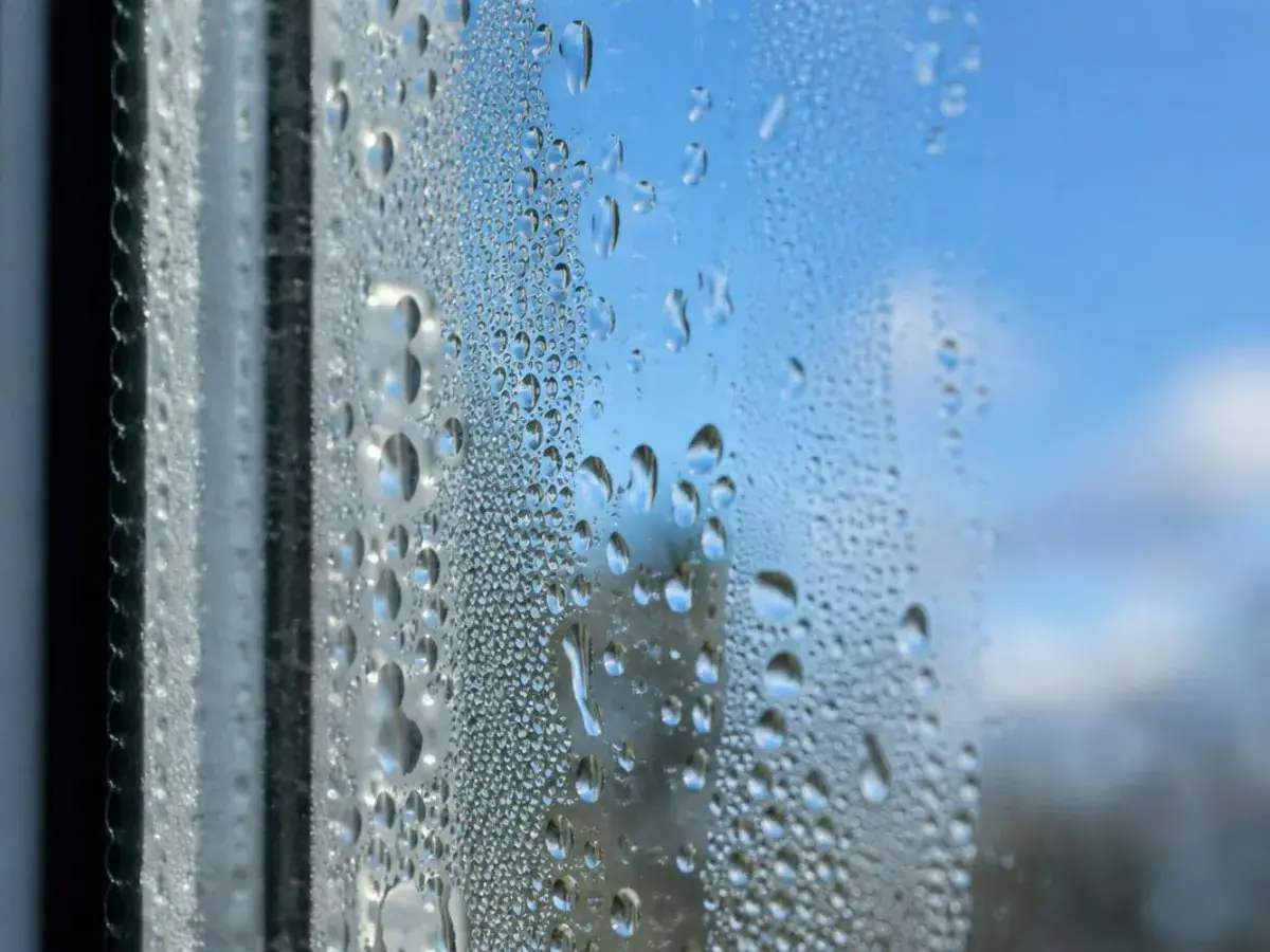 Gros plan sur des gouttelettes de condensation piégées entre les deux verres d'un vitrage, intervention à Istres